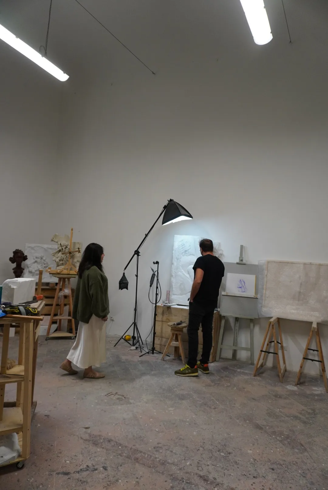 Frida and Enrico Ferrarini before a marble relief, among plaster casts and sculptures